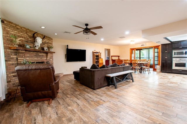 living room featuring light wood-style floors, recessed lighting, visible vents, and a ceiling fan