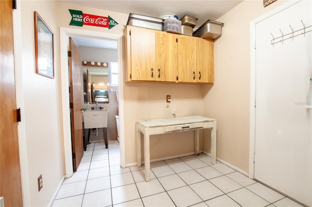 clothes washing area with light tile patterned floors