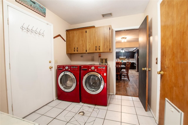 clothes washing area with light hardwood / wood-style floors, cabinets, and washer and dryer