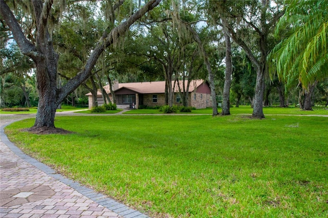 ranch-style home with stone siding and a front lawn