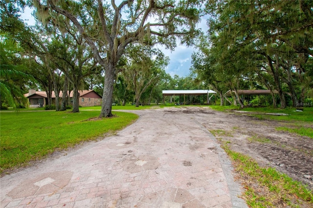 exterior space featuring aphalt driveway and a lawn