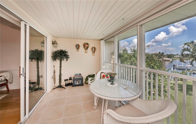 sunroom / solarium with wooden ceiling and a water view