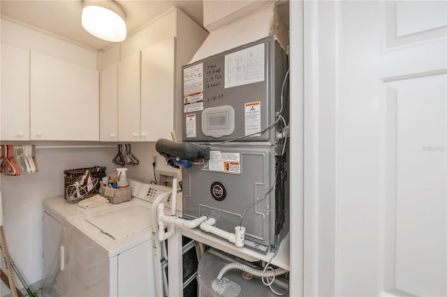 utility room with washing machine and clothes dryer and heating unit