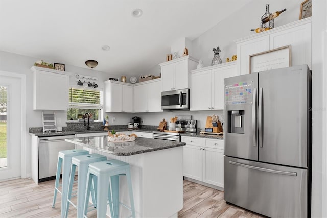 kitchen featuring white cabinetry, a center island, stainless steel appliances, and sink