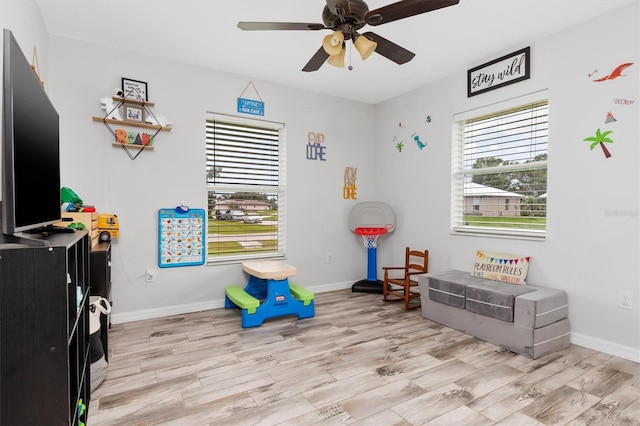 recreation room featuring ceiling fan and light hardwood / wood-style flooring