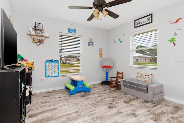 playroom featuring ceiling fan, light wood-style flooring, and baseboards