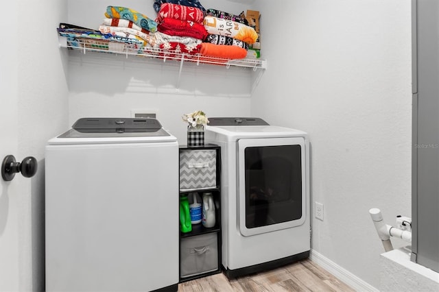 laundry room with light hardwood / wood-style flooring and separate washer and dryer