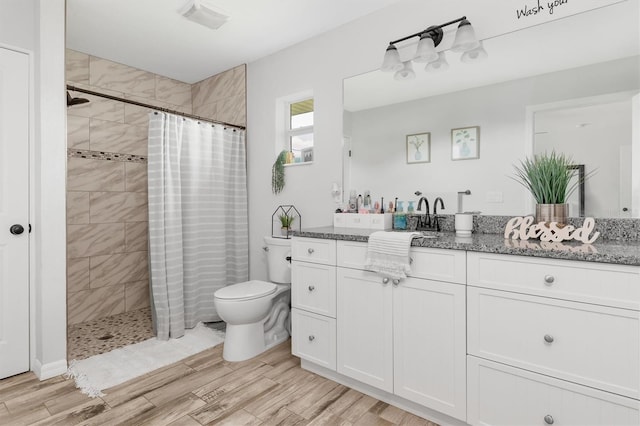 bathroom with toilet, walk in shower, and vanity