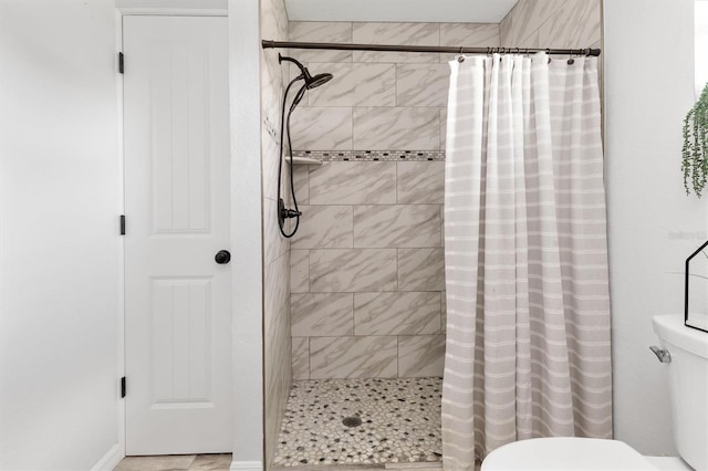 bathroom featuring toilet and a shower with shower curtain