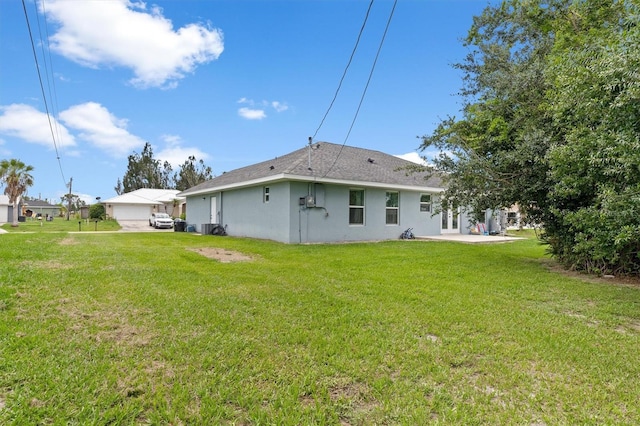 rear view of house featuring a garage and a yard