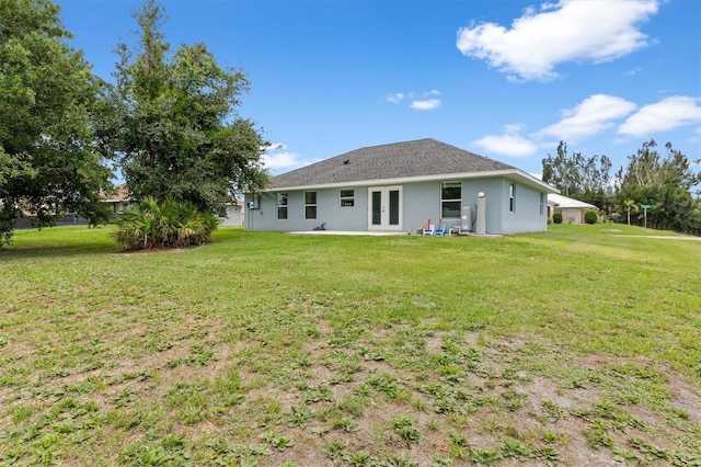 rear view of property with a lawn