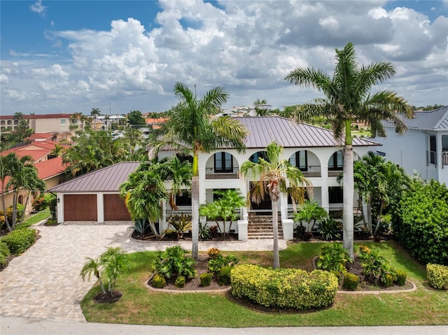 mediterranean / spanish-style home featuring a garage and an outbuilding