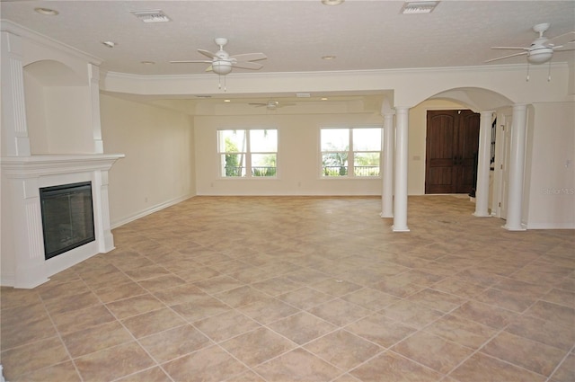 unfurnished living room featuring ornamental molding, a glass covered fireplace, ornate columns, and a ceiling fan