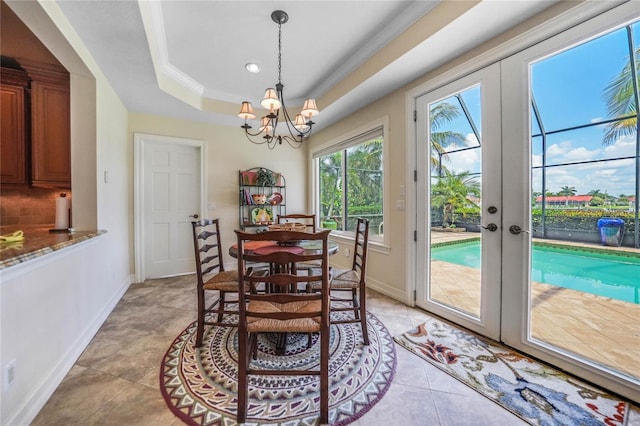 dining space featuring light tile patterned floors, baseboards, an inviting chandelier, a tray ceiling, and french doors