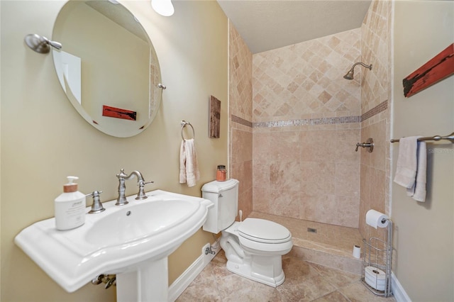 full bath featuring tile patterned flooring, baseboards, tiled shower, and toilet