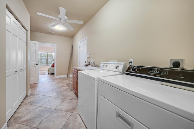 laundry room featuring cabinet space, a sink, washer and clothes dryer, and light tile patterned flooring