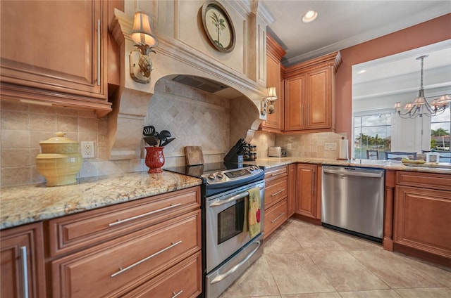 kitchen featuring light stone counters, brown cabinets, stainless steel appliances, a chandelier, and light tile patterned flooring