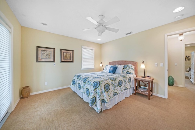 carpeted bedroom with a ceiling fan, visible vents, and baseboards