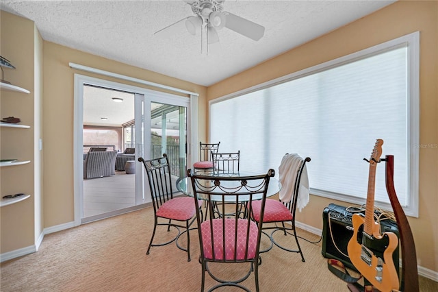 dining room featuring a textured ceiling, carpet floors, a ceiling fan, and baseboards