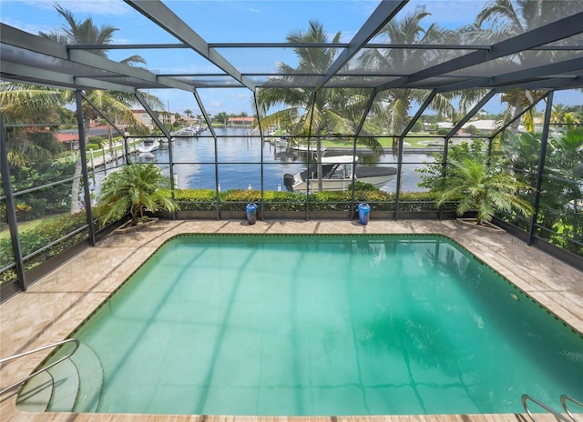 outdoor pool with a water view, glass enclosure, and a patio area