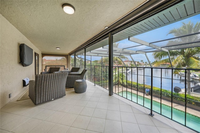 view of patio / terrace with a water view, a lanai, and an outdoor pool