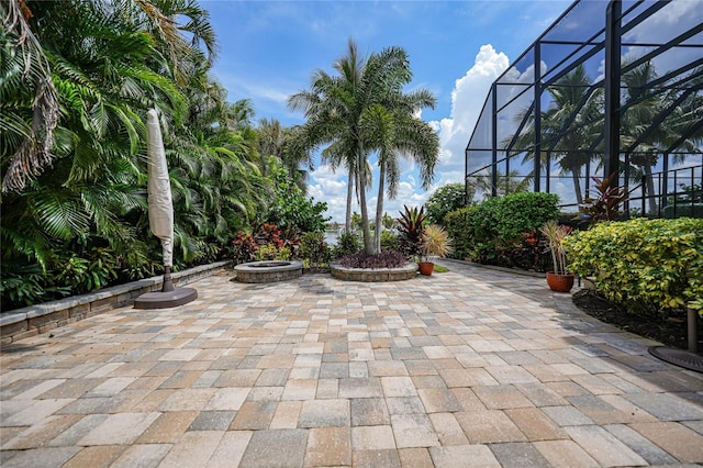 view of patio / terrace with glass enclosure and a fire pit