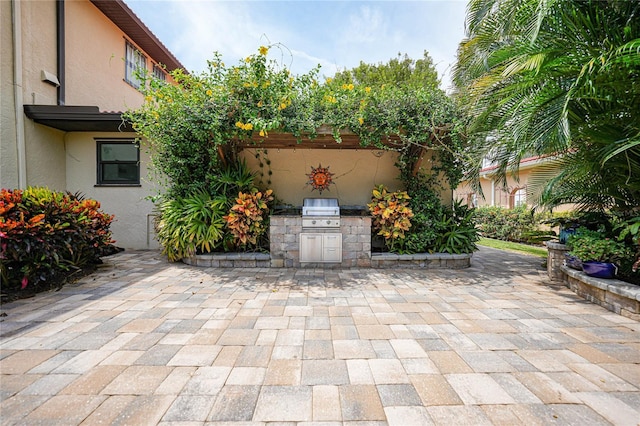 view of patio / terrace featuring exterior kitchen and a grill