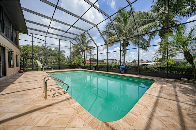 outdoor pool with glass enclosure and a patio area