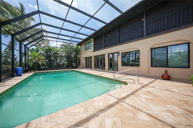 outdoor pool with glass enclosure and a patio area