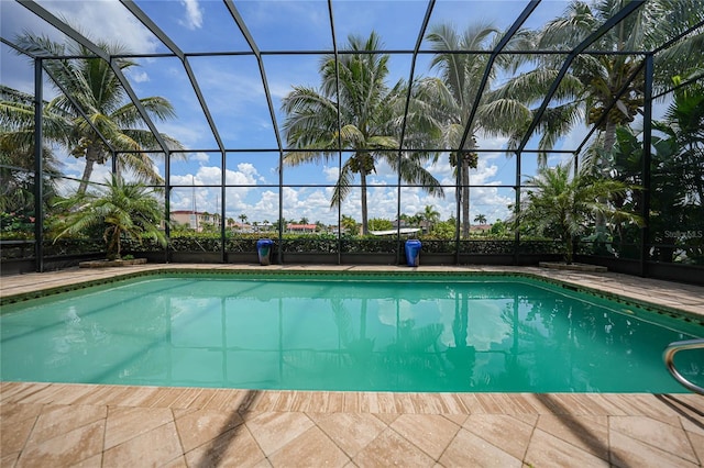 outdoor pool with glass enclosure and a patio