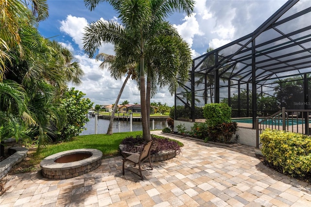 view of patio / terrace with a water view, glass enclosure, and an outdoor pool