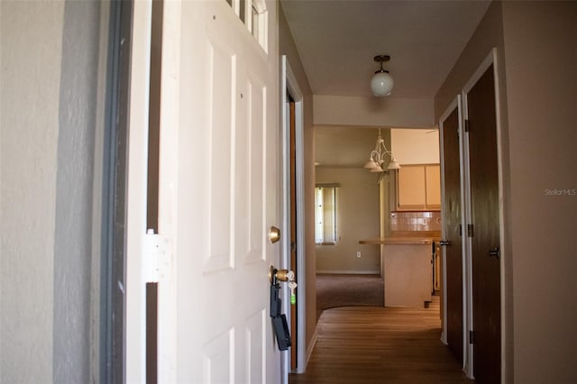 hallway featuring a notable chandelier and dark hardwood / wood-style floors