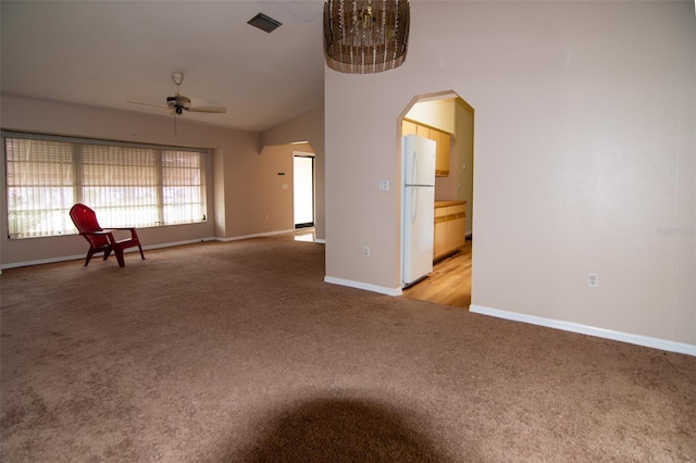 carpeted spare room featuring ceiling fan and vaulted ceiling