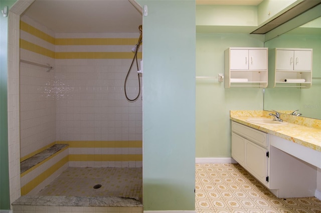 bathroom with vanity and a tile shower