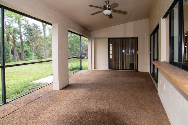 unfurnished sunroom with ceiling fan and vaulted ceiling