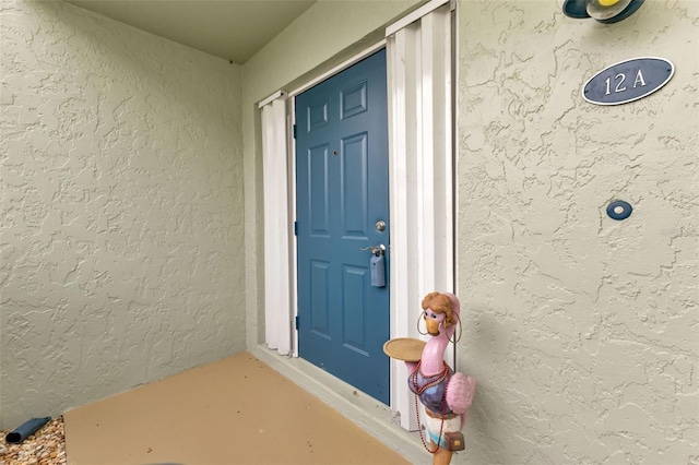 entrance to property featuring stucco siding