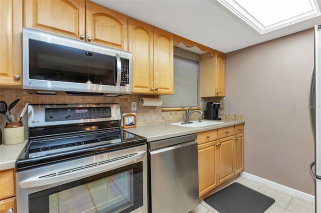 kitchen featuring tasteful backsplash, sink, light tile patterned floors, and stainless steel appliances