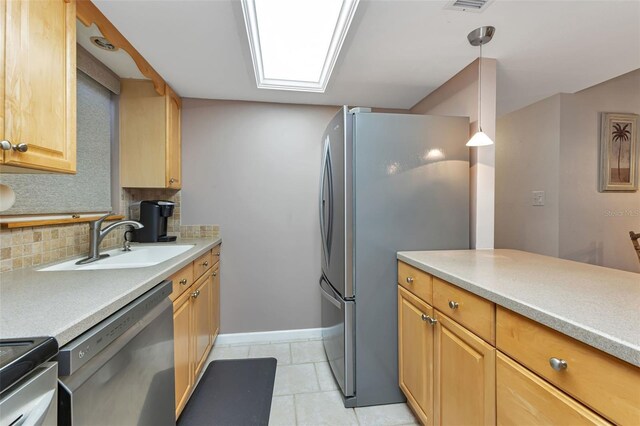 kitchen featuring light brown cabinetry, tasteful backsplash, stainless steel appliances, sink, and decorative light fixtures