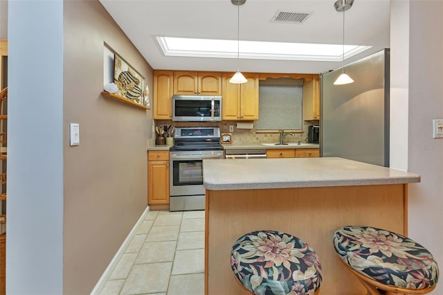 kitchen with tasteful backsplash, sink, hanging light fixtures, and appliances with stainless steel finishes