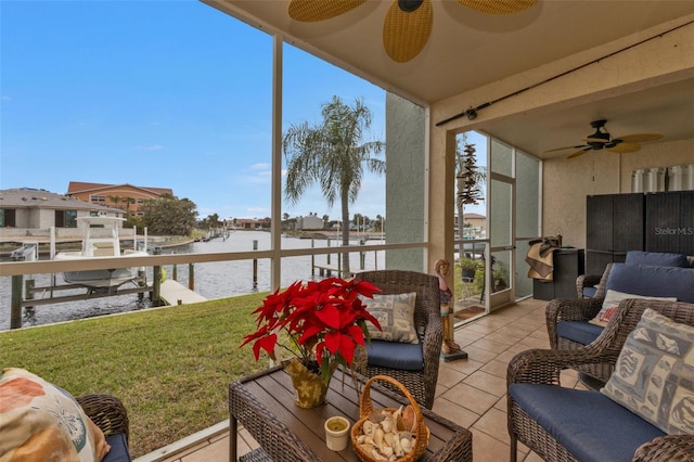 sunroom / solarium with ceiling fan, plenty of natural light, and a water view