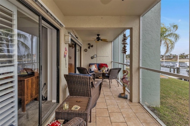 balcony featuring ceiling fan and a water view