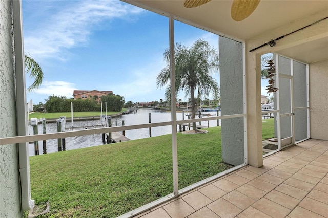 unfurnished sunroom featuring a water view and ceiling fan