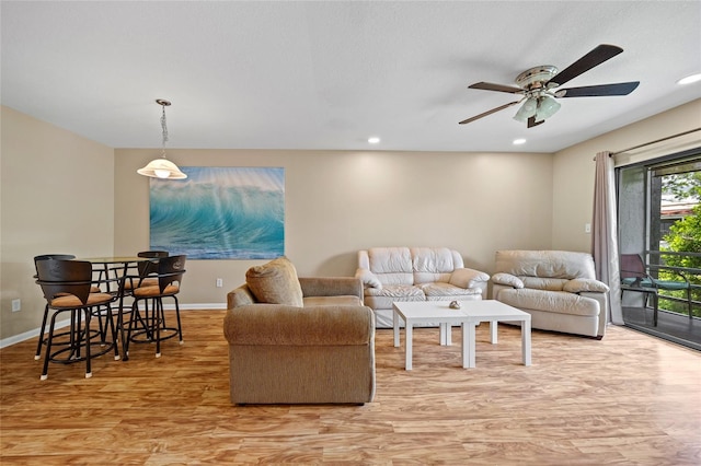 living room with a wealth of natural light, ceiling fan, and light hardwood / wood-style floors