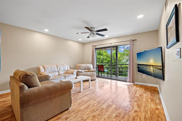 living room featuring ceiling fan and light hardwood / wood-style floors