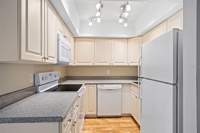 kitchen featuring track lighting, white appliances, cream cabinetry, and light hardwood / wood-style floors