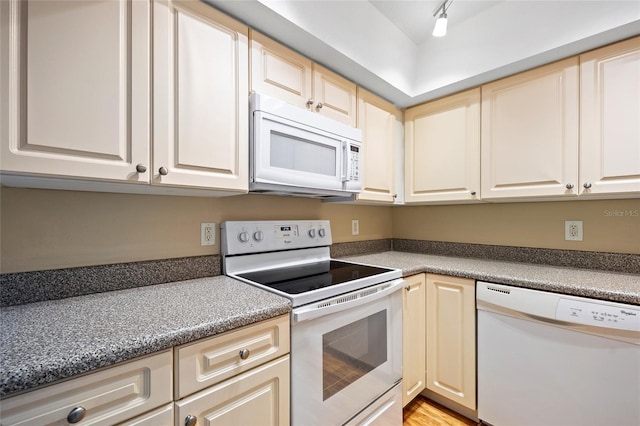 kitchen with white appliances, track lighting, and light hardwood / wood-style floors