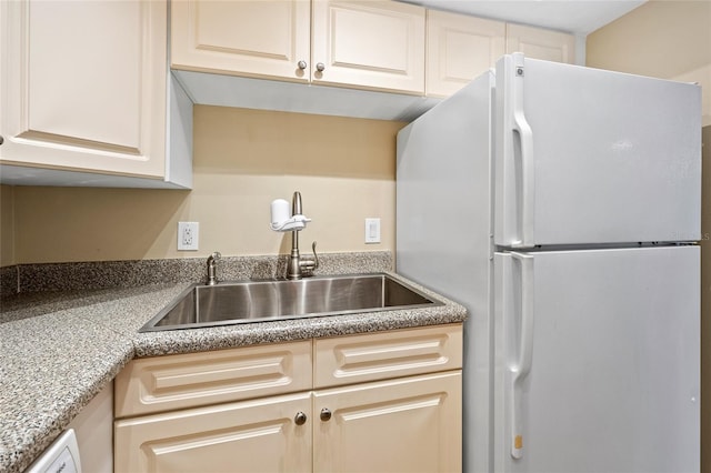 kitchen featuring white refrigerator and sink