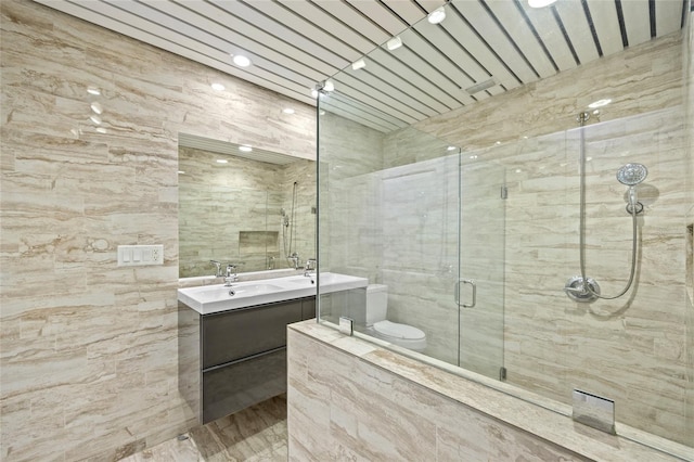 bathroom with a shower with shower door, toilet, and vanity