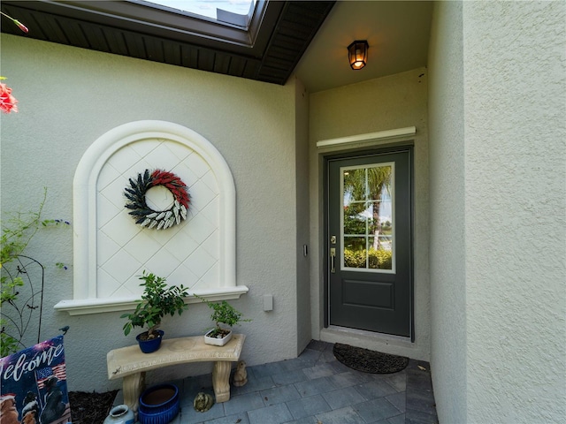 doorway to property featuring stucco siding