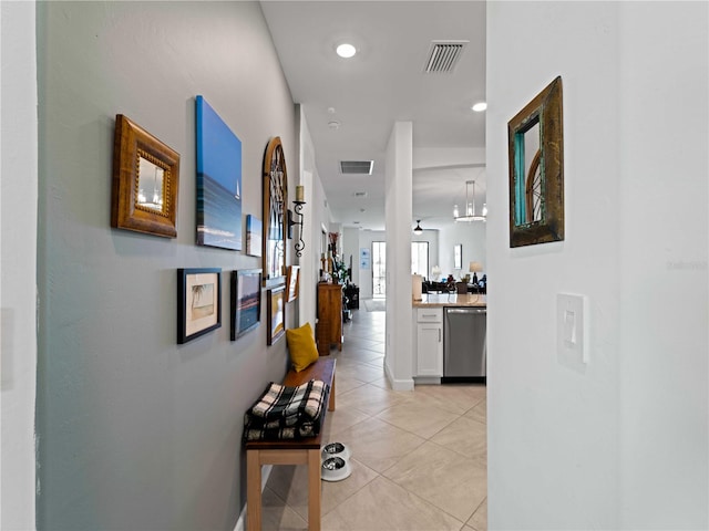 hall featuring an inviting chandelier and light tile patterned flooring